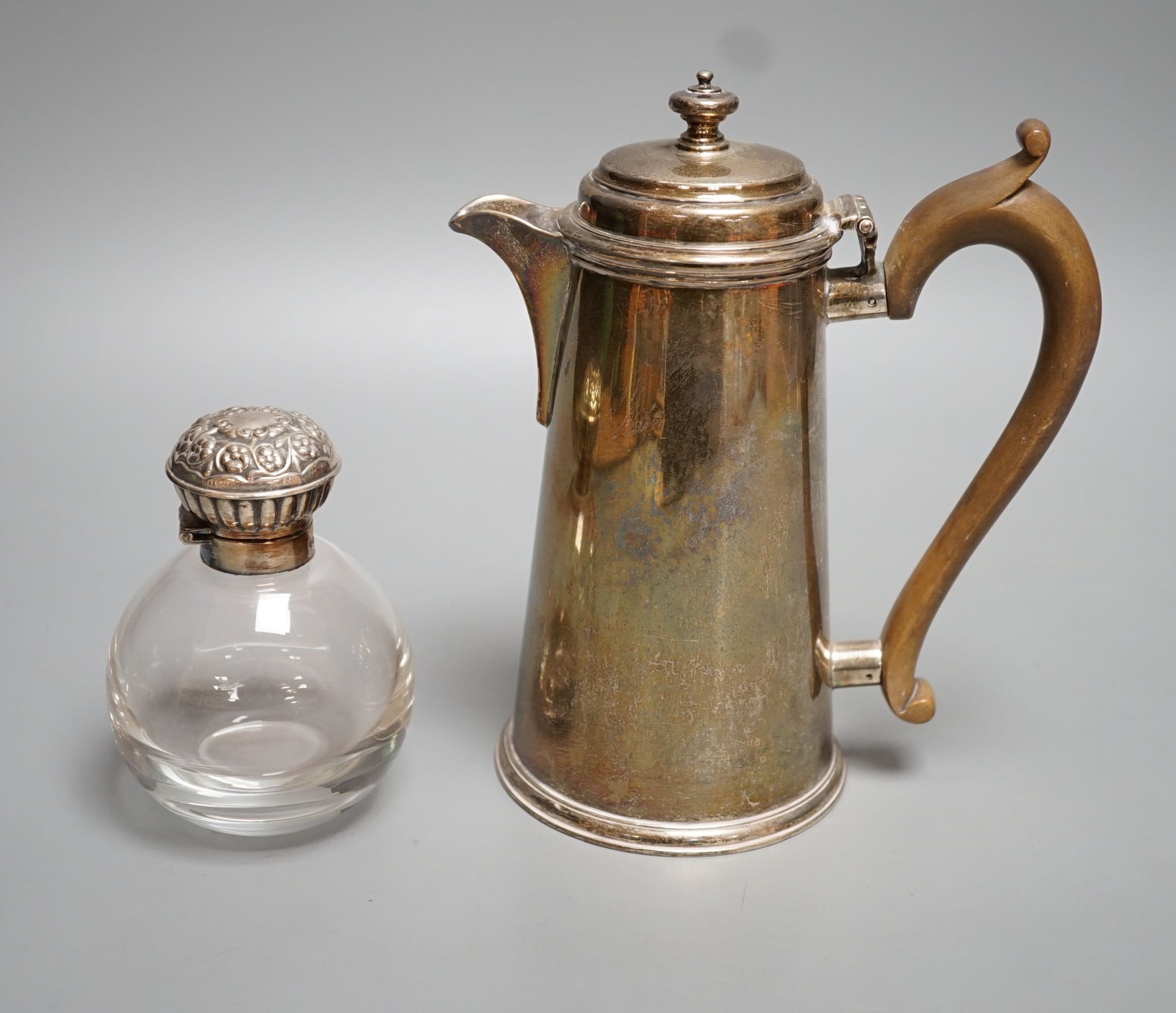 A George V silver hot water pot, London, 1934, gross 15oz and a silver topped glass scent bottle.